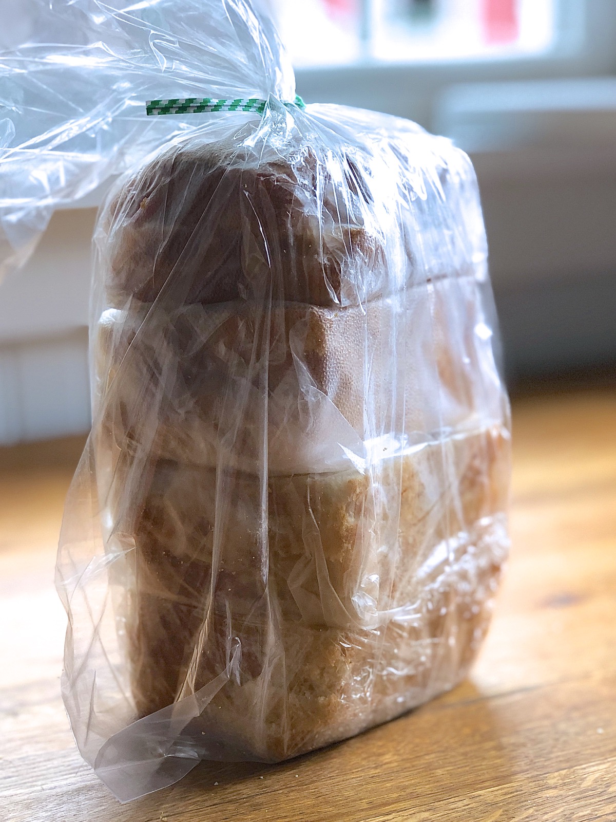 Individual packets of sandwich bread stored in a plastic bag, ready for the freezer.