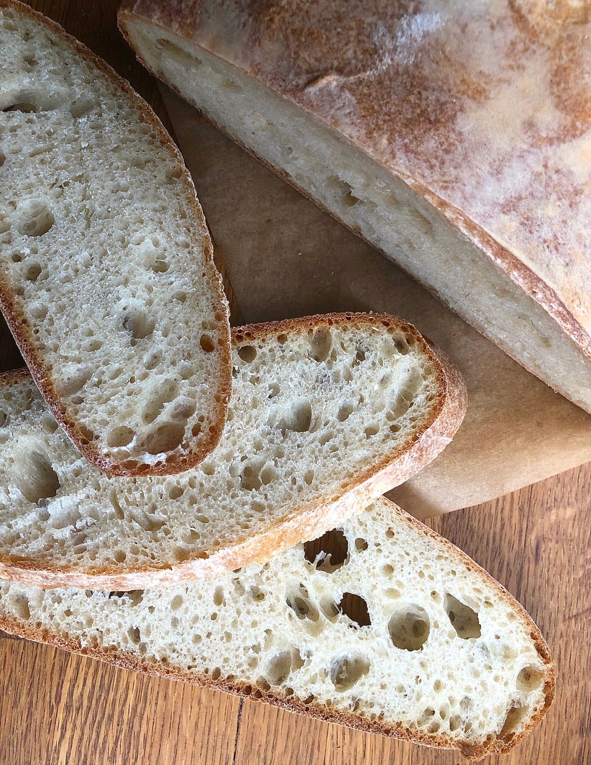 Top-down view of round loaf of sourdough bread on a counter, sliced.