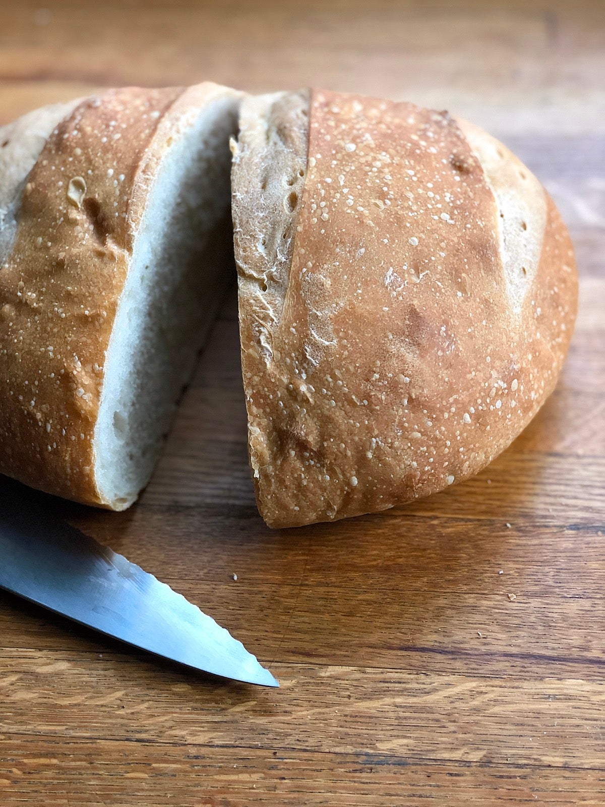 Large round loaf on a counter, cut in half.