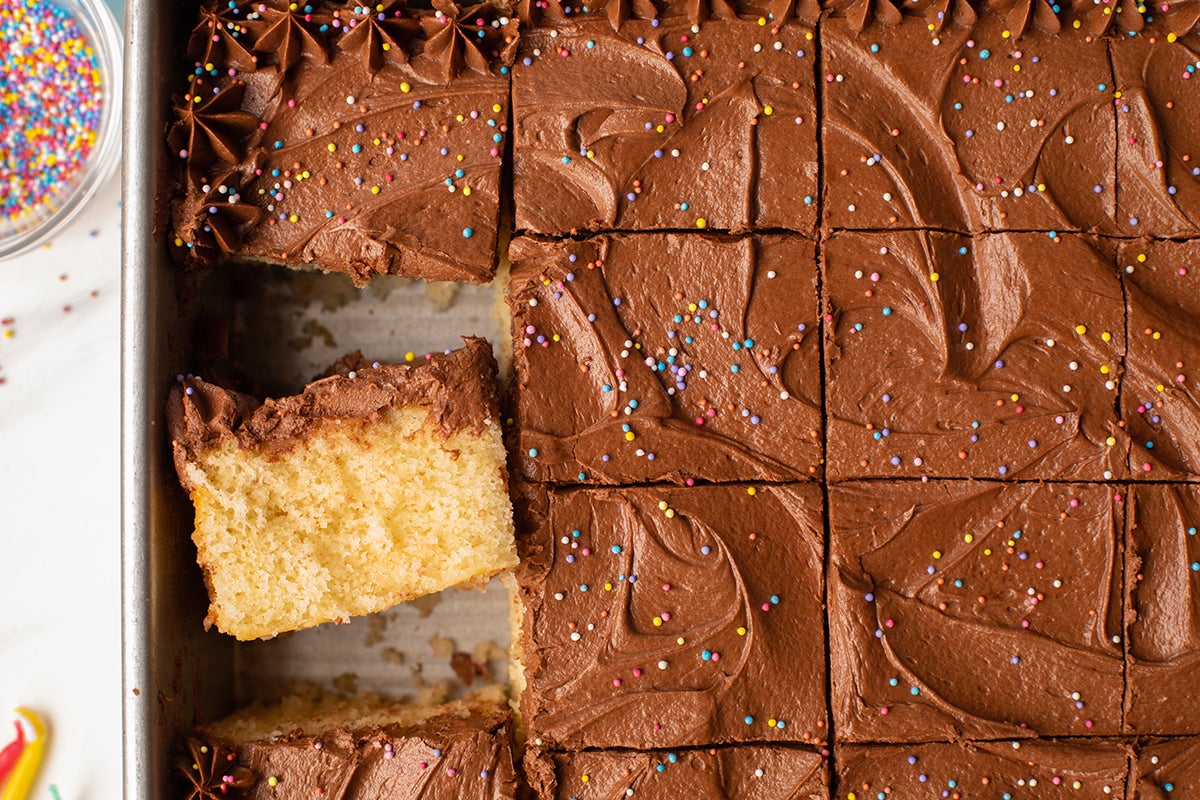 Classic Birthday Cake baked in a sheet pan, sliced and decorated with rainbow sprinkles