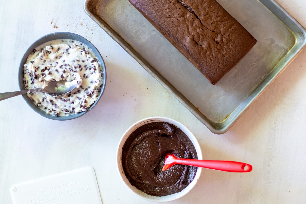 Chocolate Cassata cake, filling mixture, and frosting set out for assembling