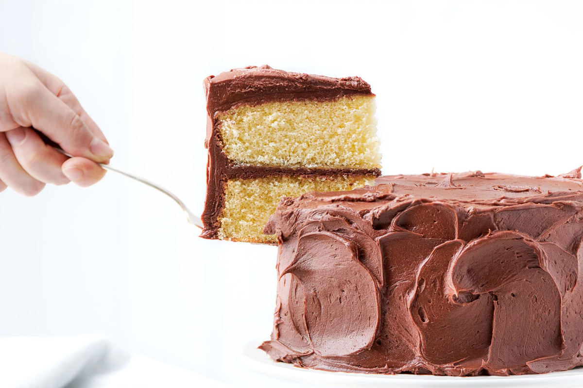 Slice being lifted from chocolate-frosted yellow cake
