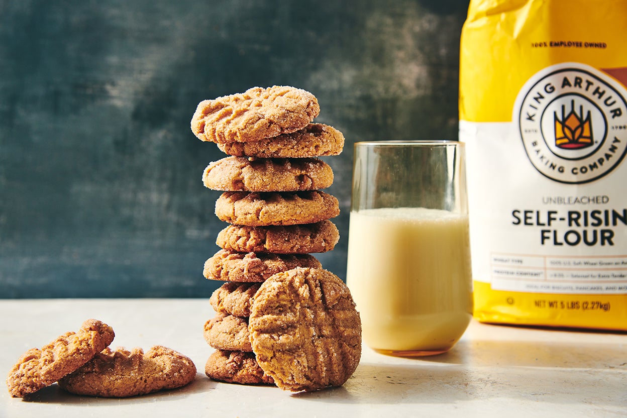 Measuring cups of flour and sugar with a peanut butter mixture in