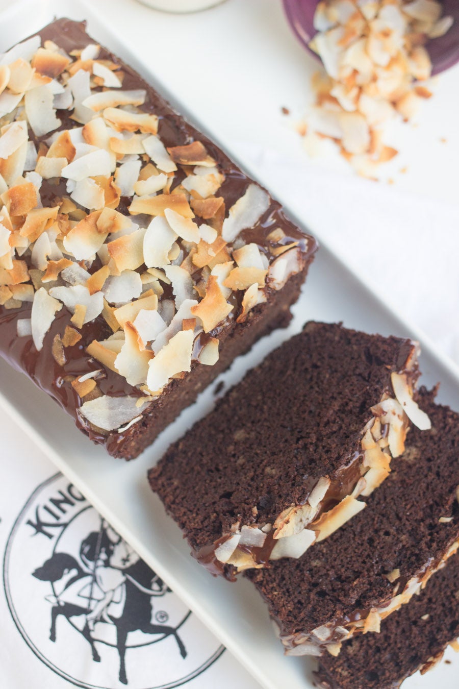 Gluten-Free Coconut Flour Chocolate Cake topped with a Chocolate Glaze and Toasted Coconut Chips