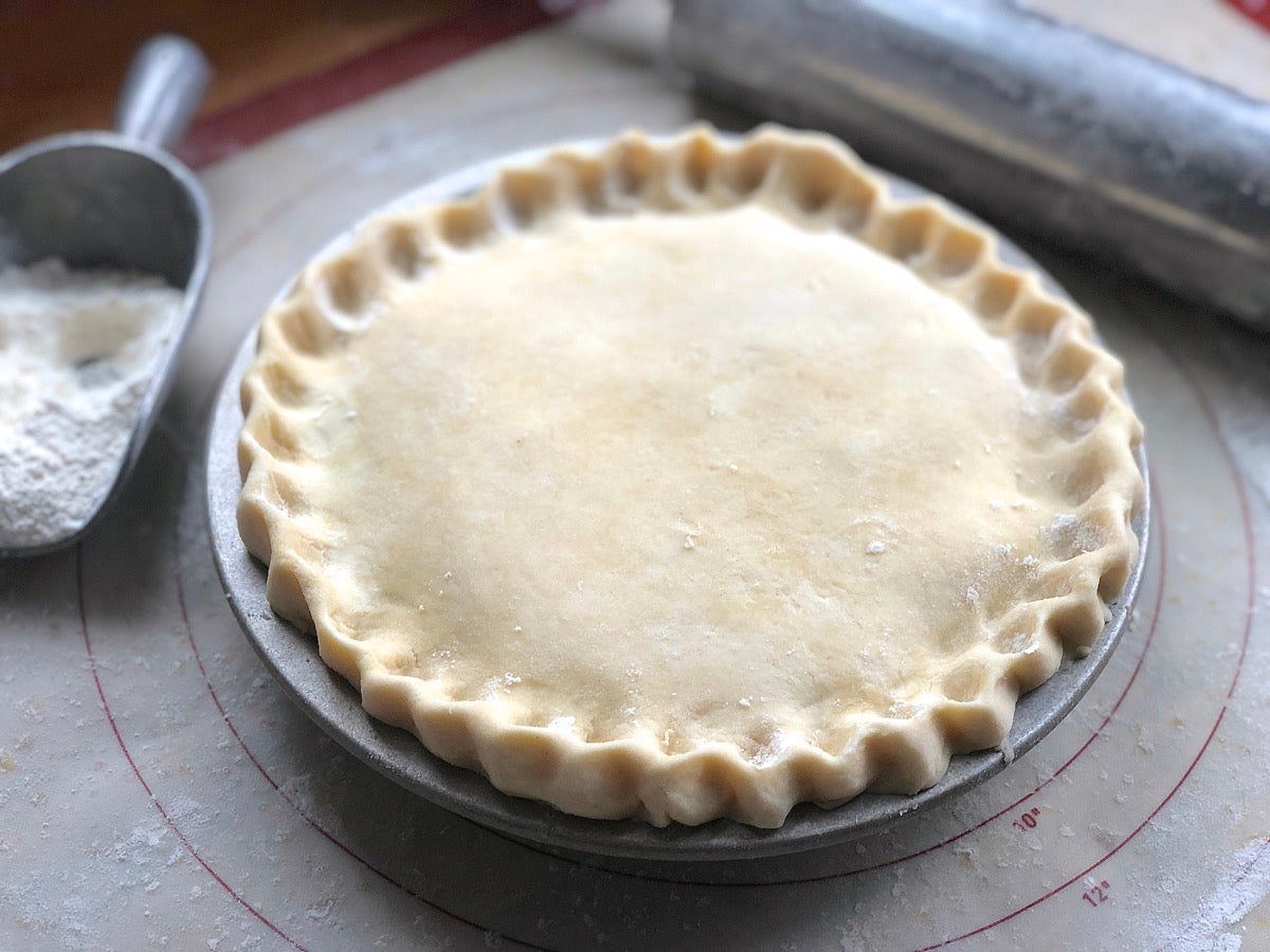 Peach-apricot-raspberry pie, top crust applied and crimped