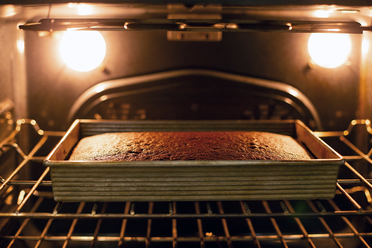 Chocolate cake in a 9" by 13" pan baking in the oven