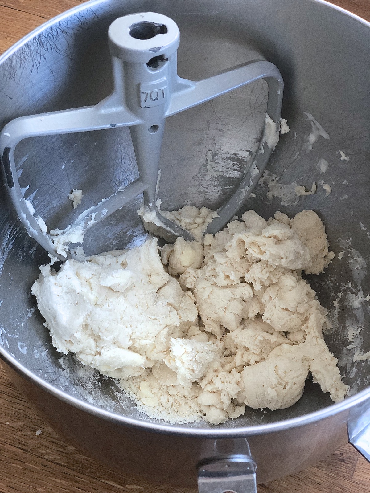 Biscuit dough being mixed in a stand mixer.