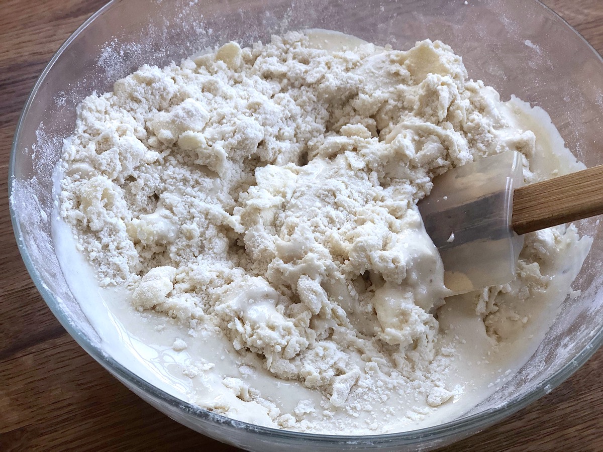 Sourdough starter being stirred into a crumbly flour/butter base.