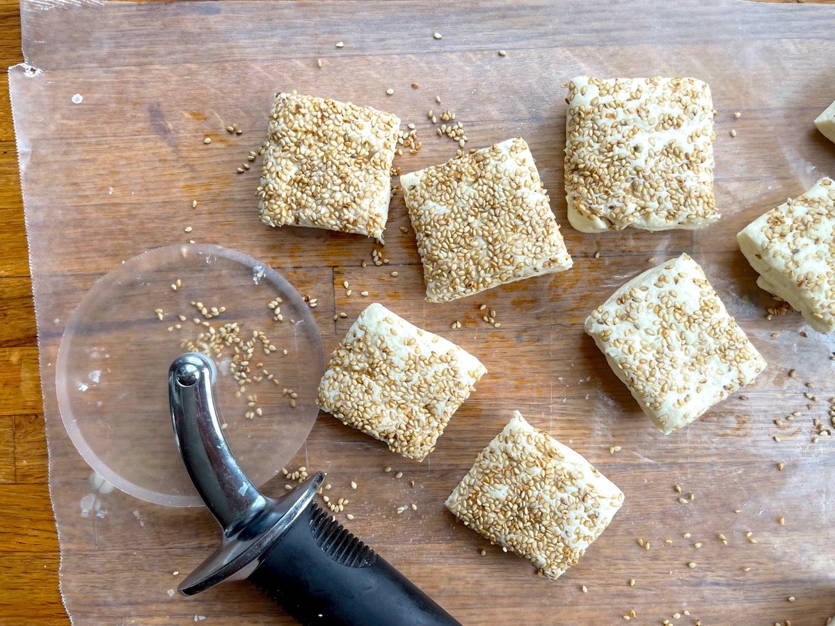 Biscuits rolled in a bed of sesame seeds and ut with a pizza wheel prior to being baked.