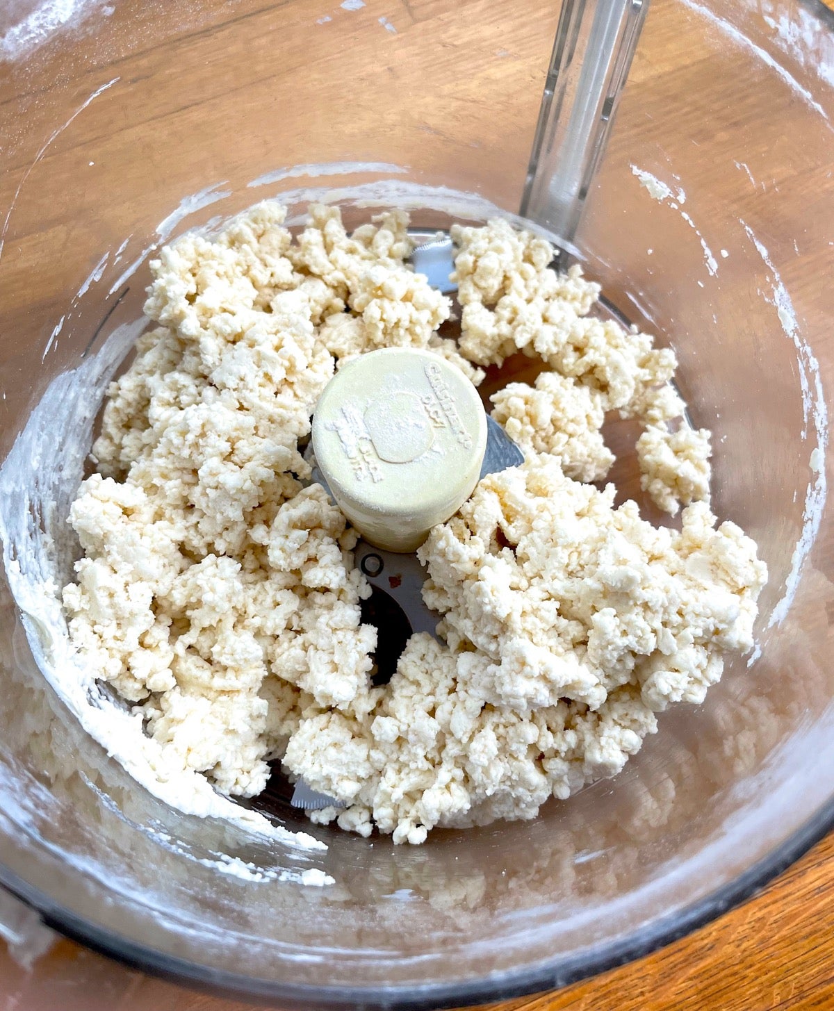 biscuit dough in a food processor, waiting to be transferred to a work surface for shaping.