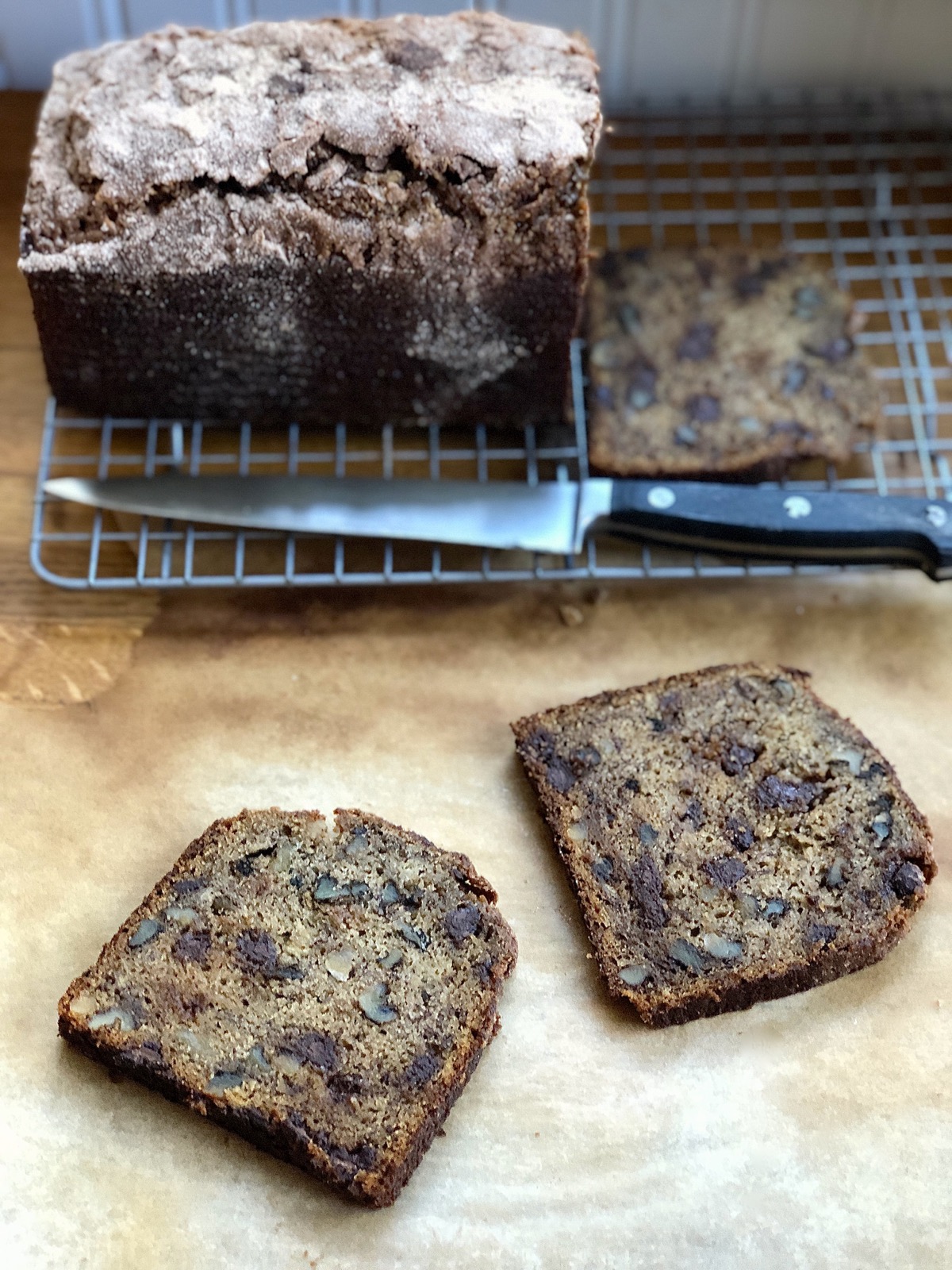 Slices of whole grain banana bread with added chocolate chips and chopped walnuts.