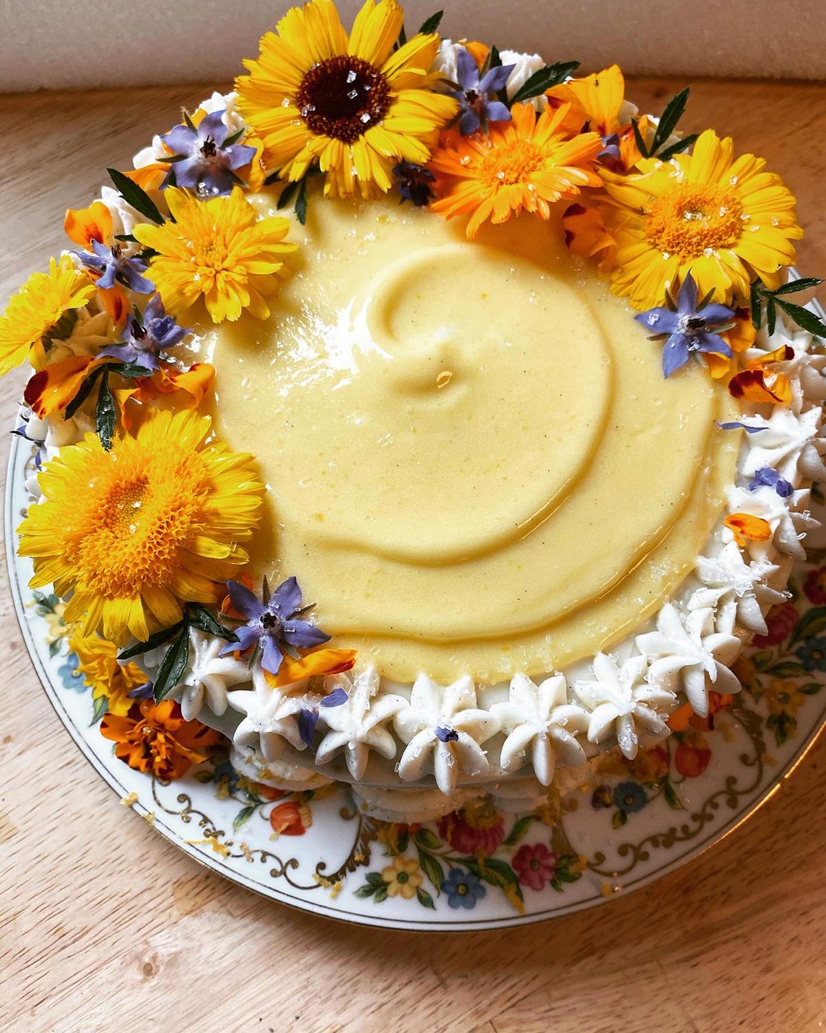 A lemon layer cake decorated with edible flowers