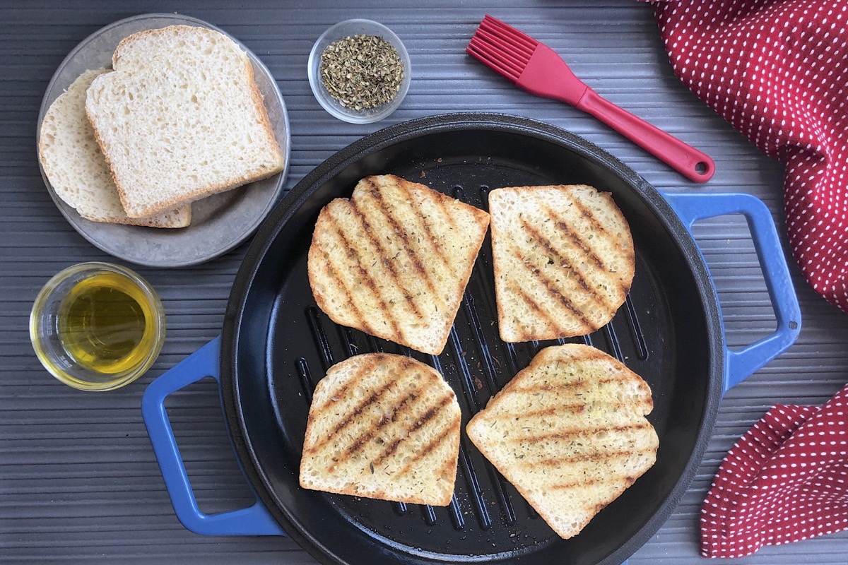 English Muffin Toasting Bread turned into Texas Toast by spreading with  butter, griddling, then sprinkling with Italian herbs and garlic powder.