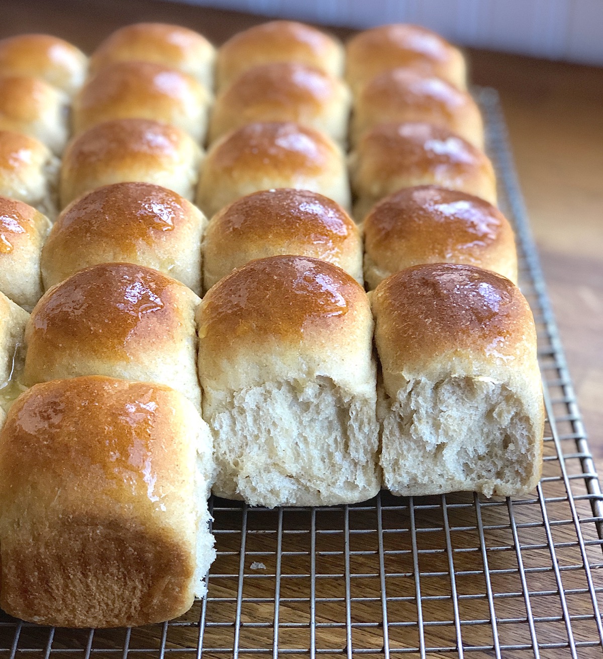Amish Dinner Rolls baked with whole wheat flour cooling on a rack.