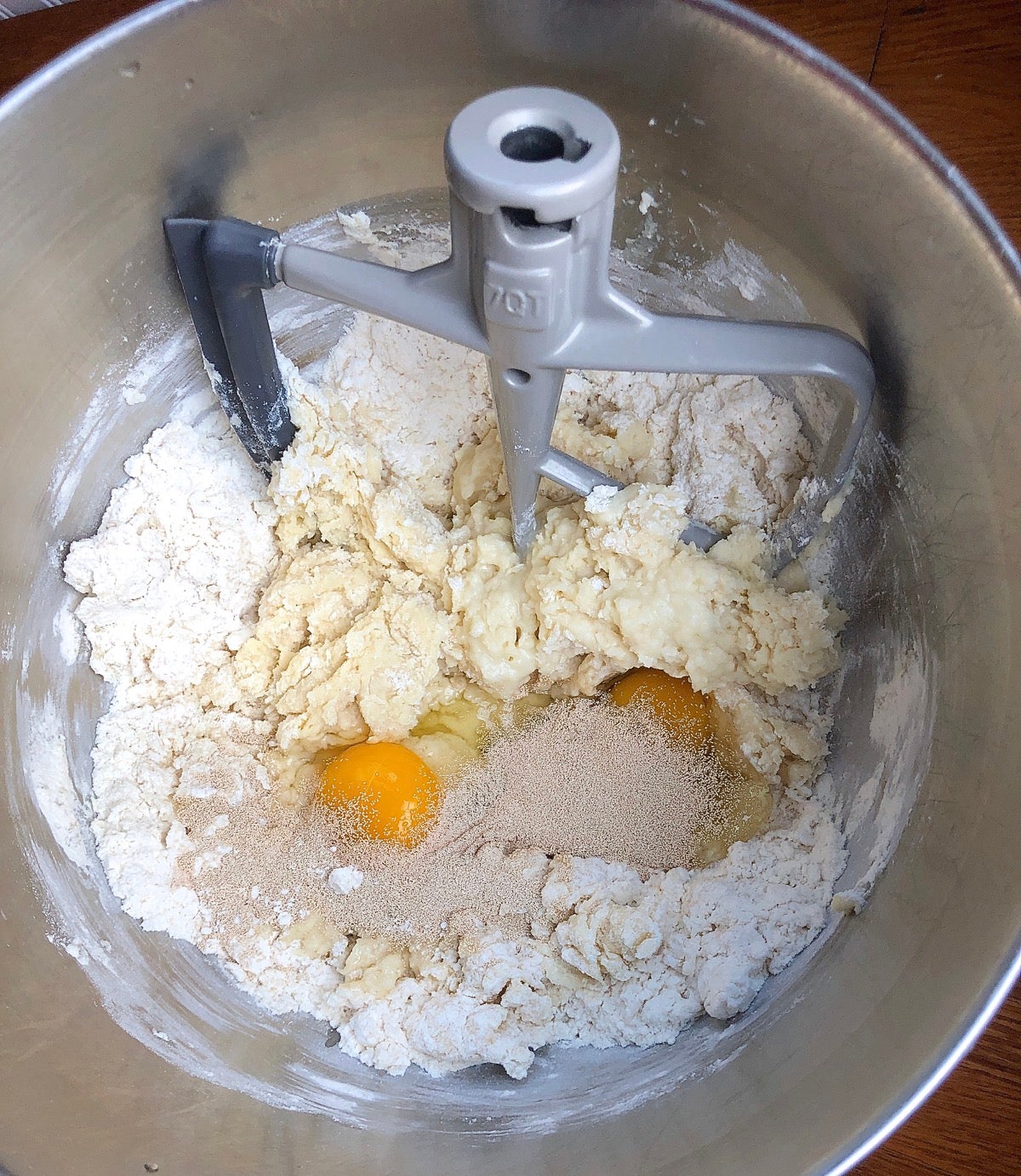 All of the ingredients for Amish Dinner Rolls in the bowl of a stand mixer, waiting to be mixed.