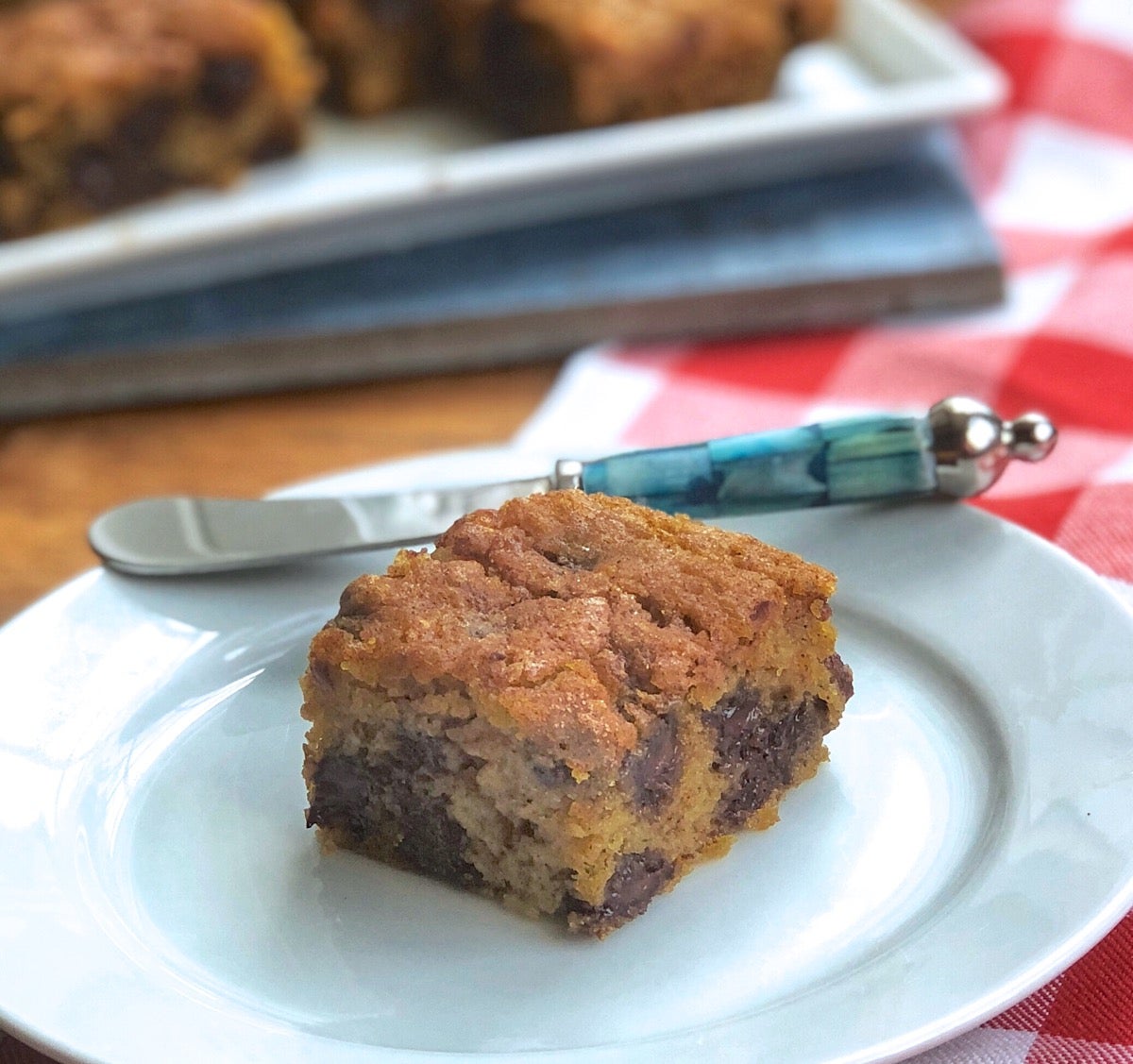 Pumpkin Chocolate Chip Cookie batter turned into bars; one bar on a plate.