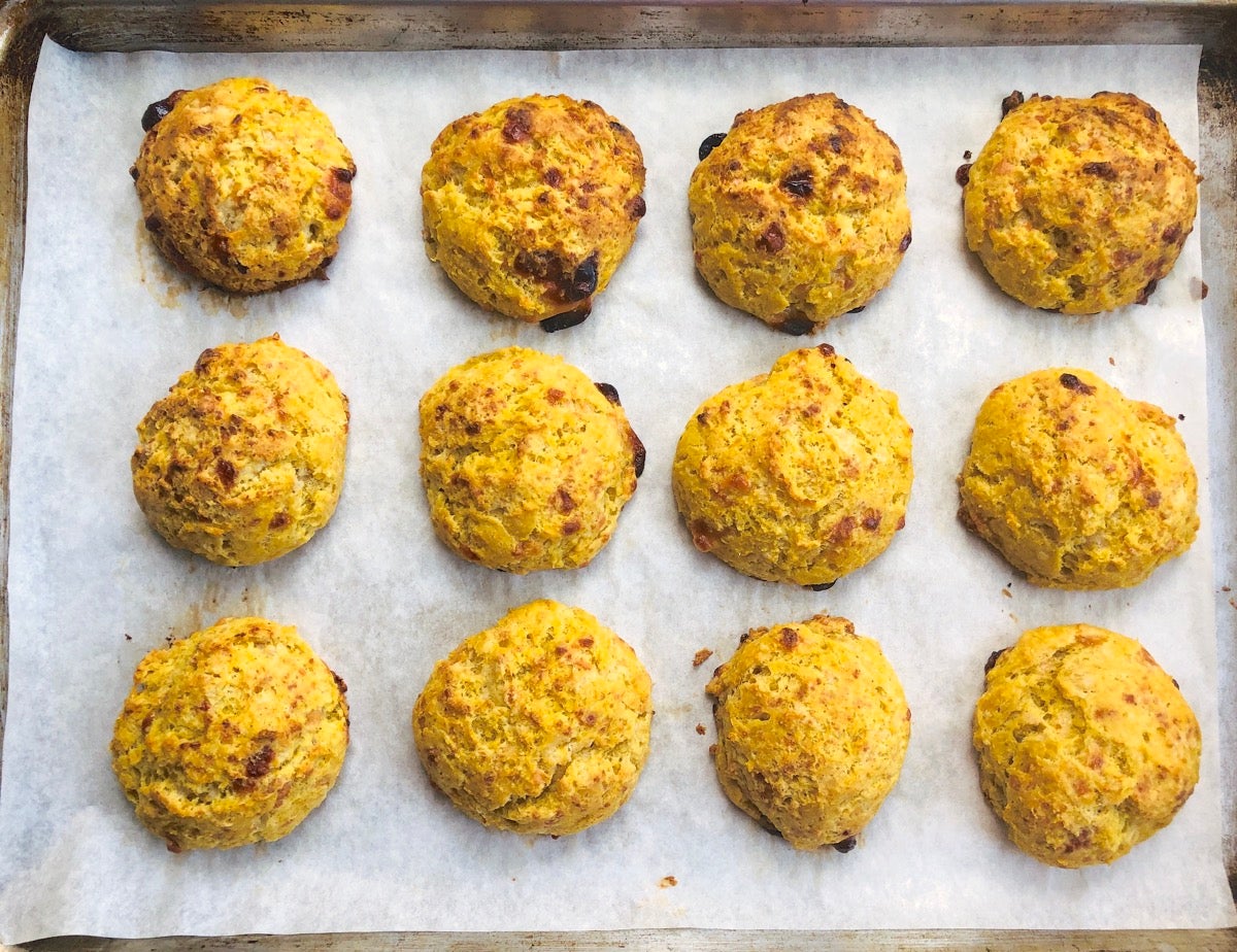 Baked pumpkin cheddar biscuits made with discard starter on a baking sheet.