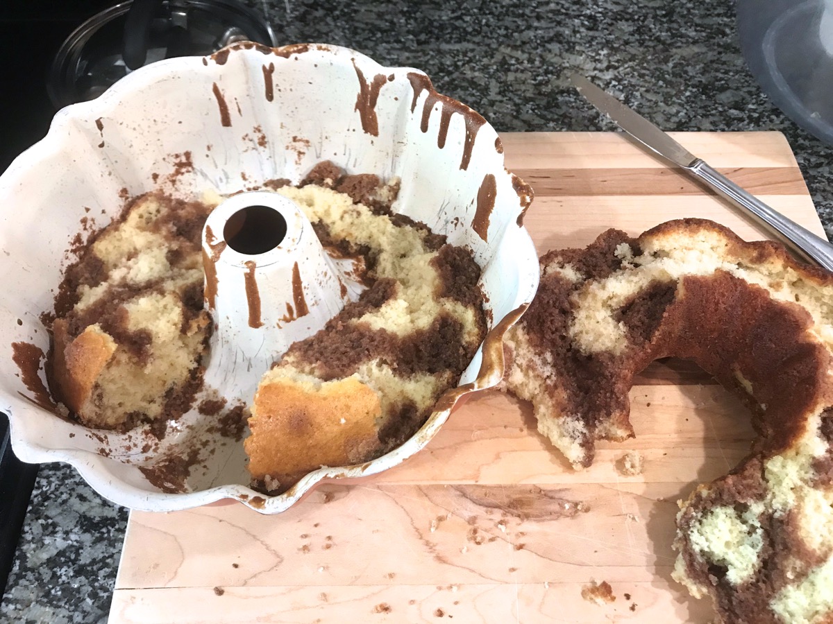 Chocolate and vanilla marbled Bundt cake, half stuck in the pan, half crumbled on the counter.