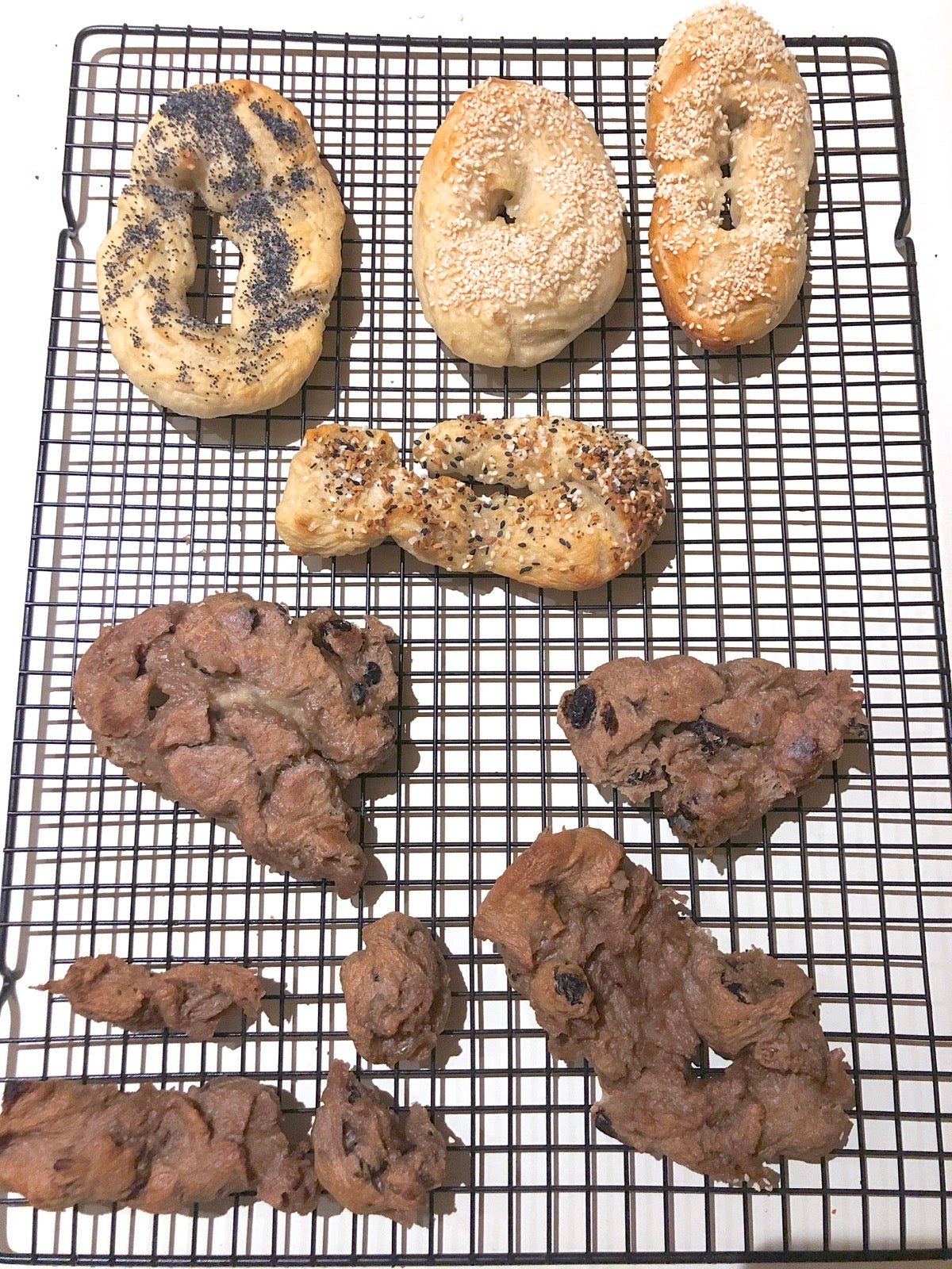 Misshapen boiled bagels on a cooling rack.