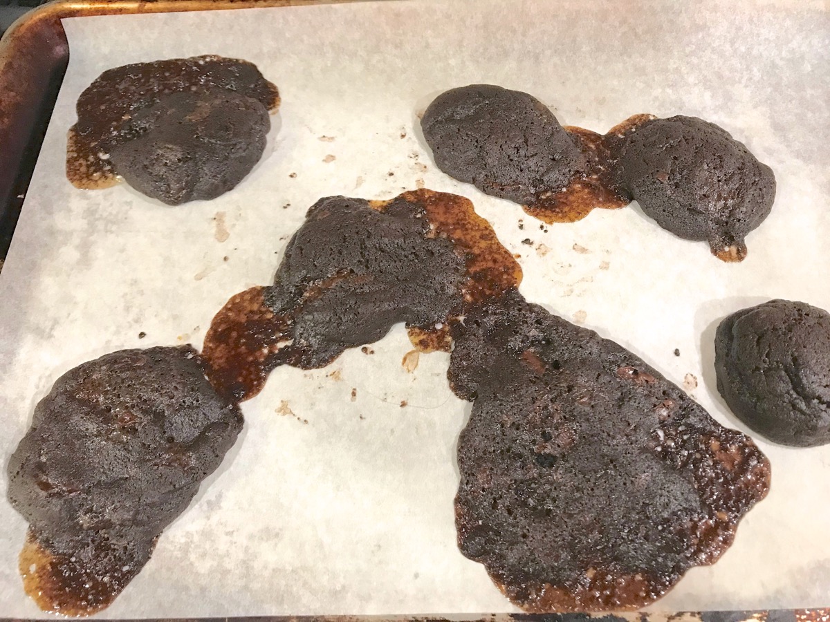 chocolate mint cookies puddled on a baking sheet.