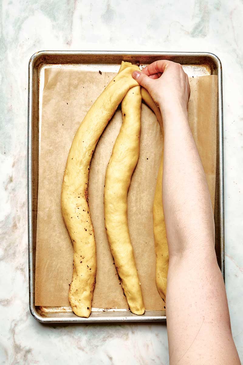 Pinching the top of three dough logs together