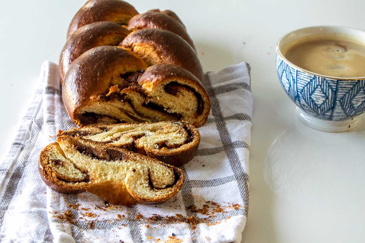 Sliced babkallah next to cup of coffee