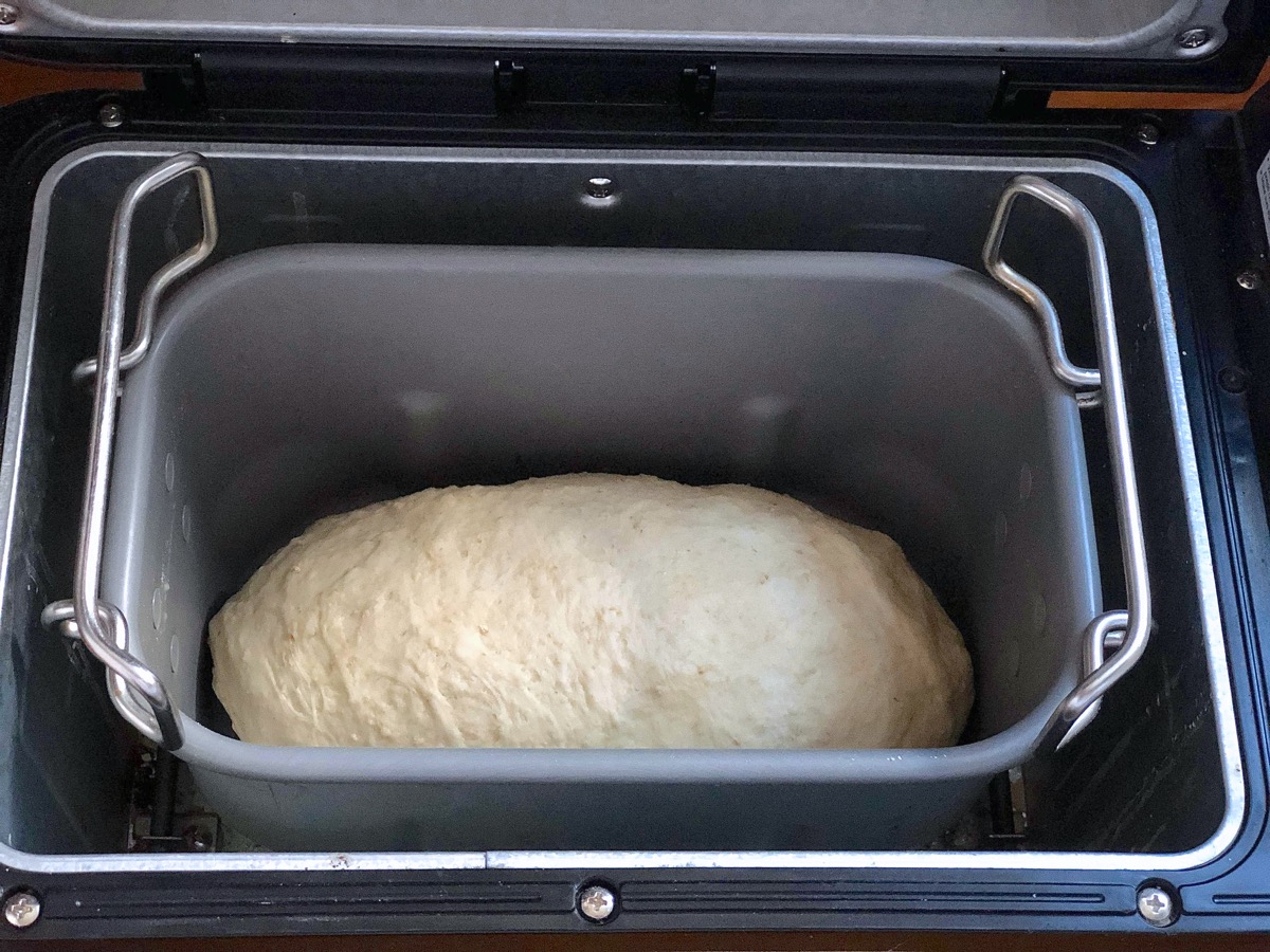 Oatmeal bread dough kneaded in a bread machine bucket