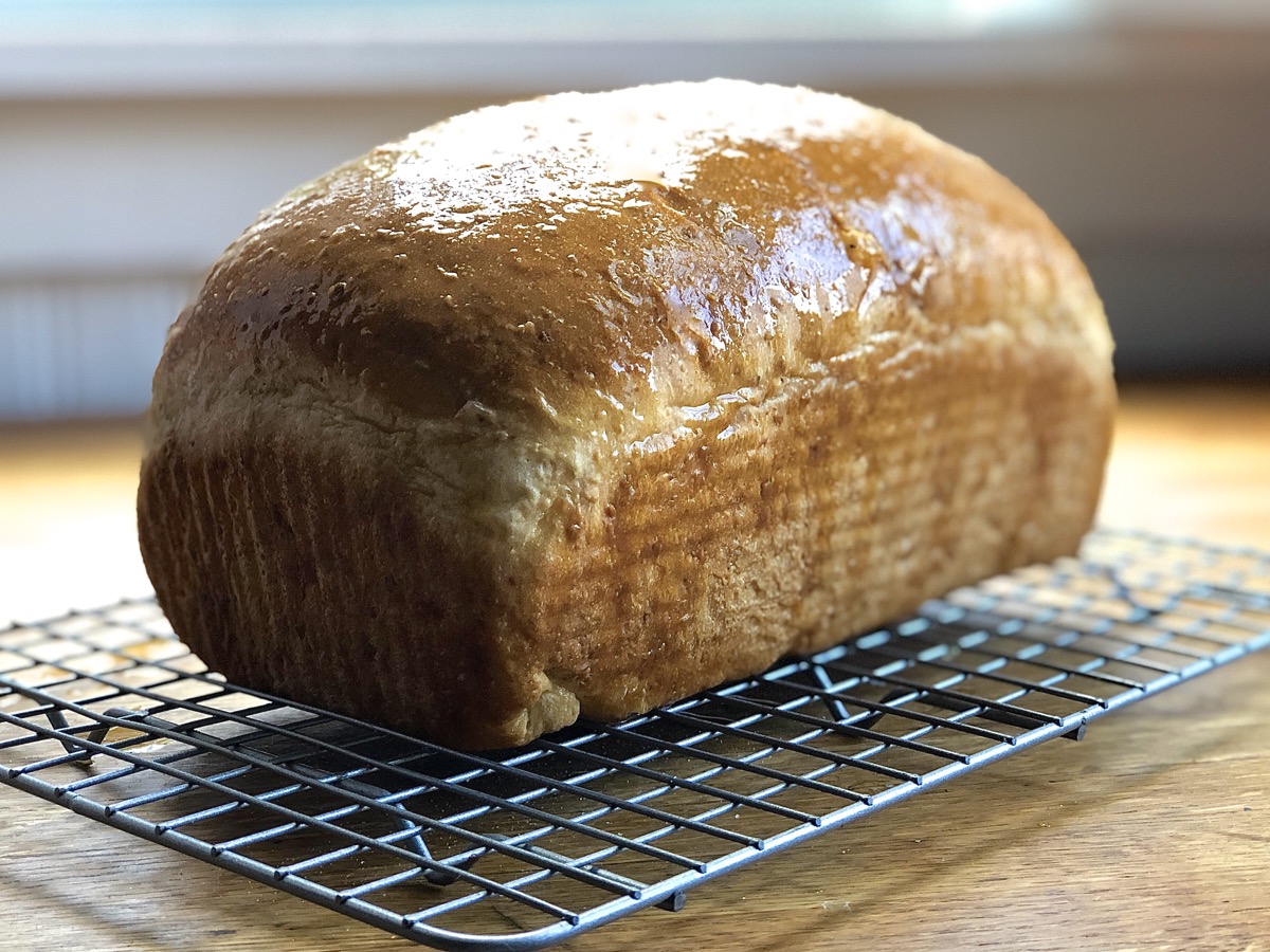 Loaf of oatmeal bred on a cooling rack.
