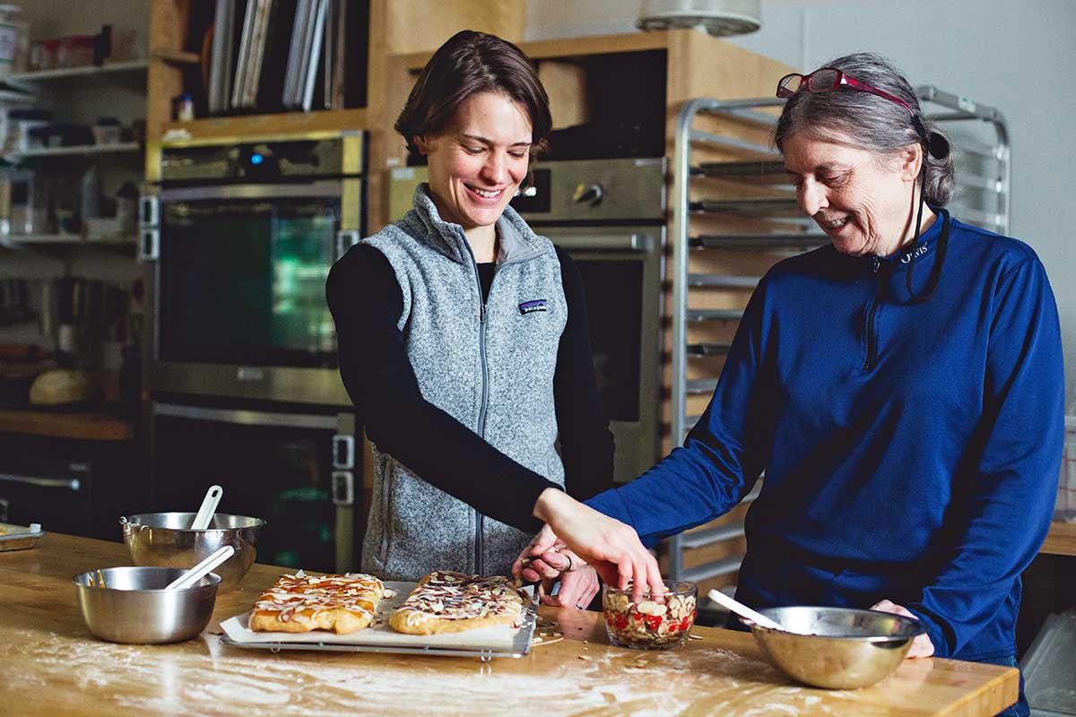 Two happy bakers putting the finishing touches on their almond puff loaf pastries