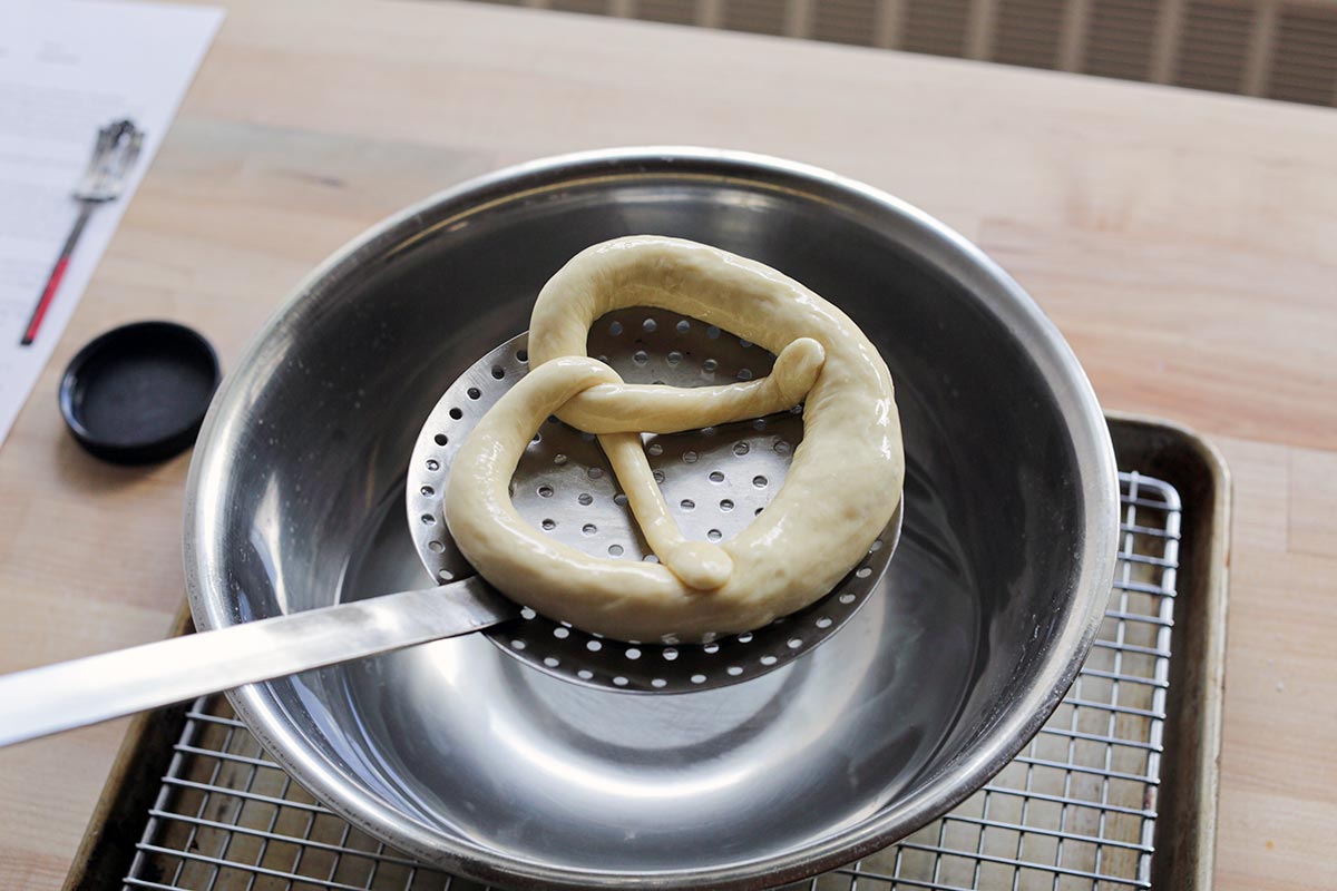 Dipping shaped pretzel dough in lye