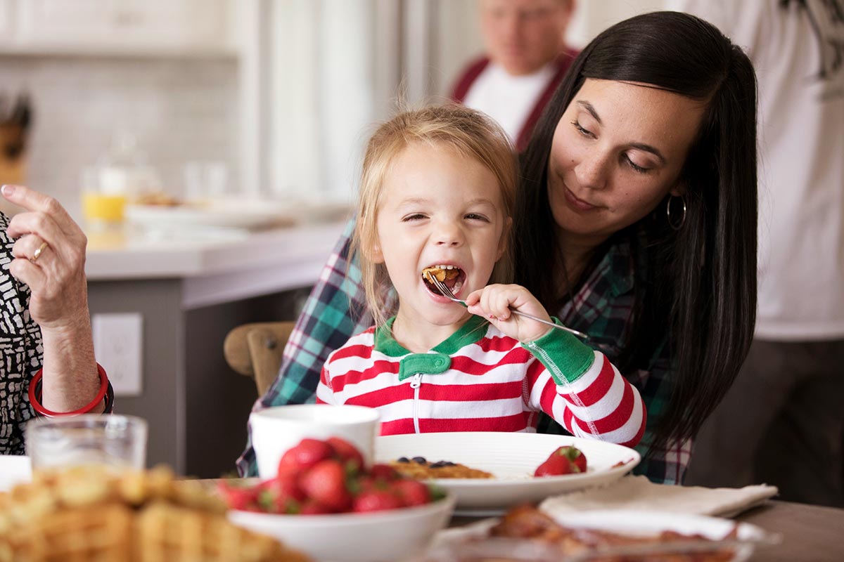 A mother and daughter enjoying waffles for breakfast together