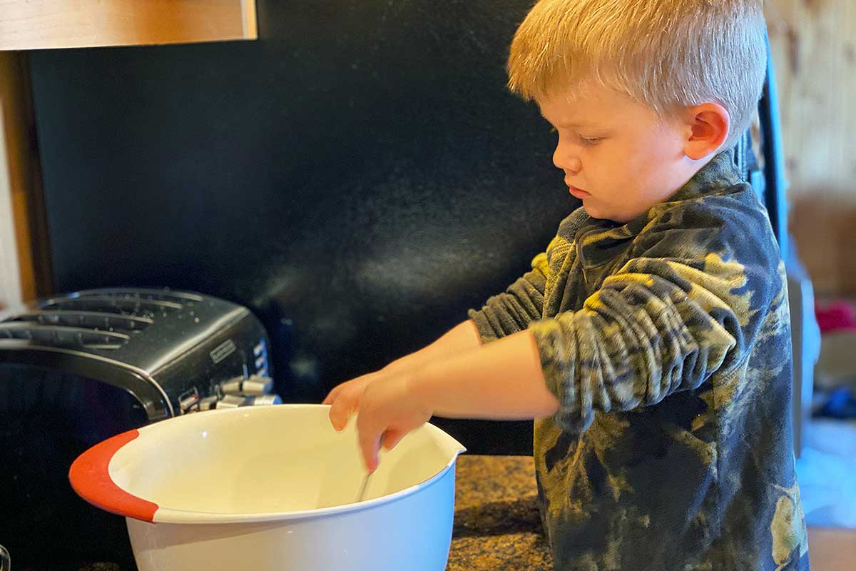 A young baker mixing a bowl of banana bread bread