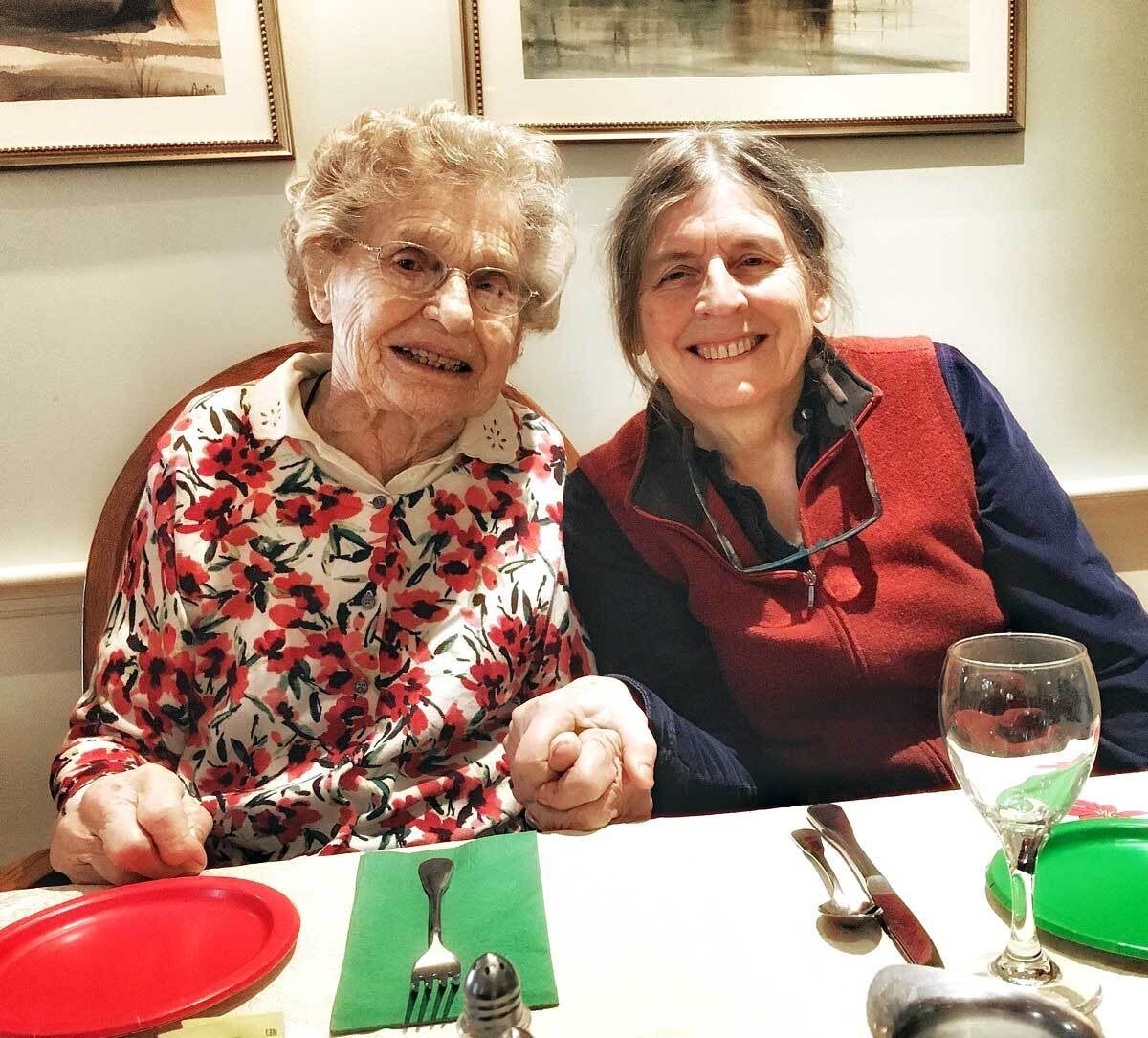 An older lady sitting happily next to her daughter