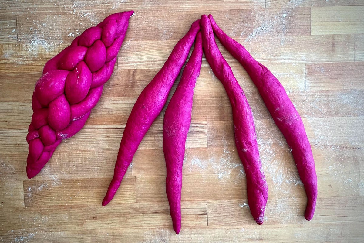 Braided challah next to four strands joined at the top and ready to braid