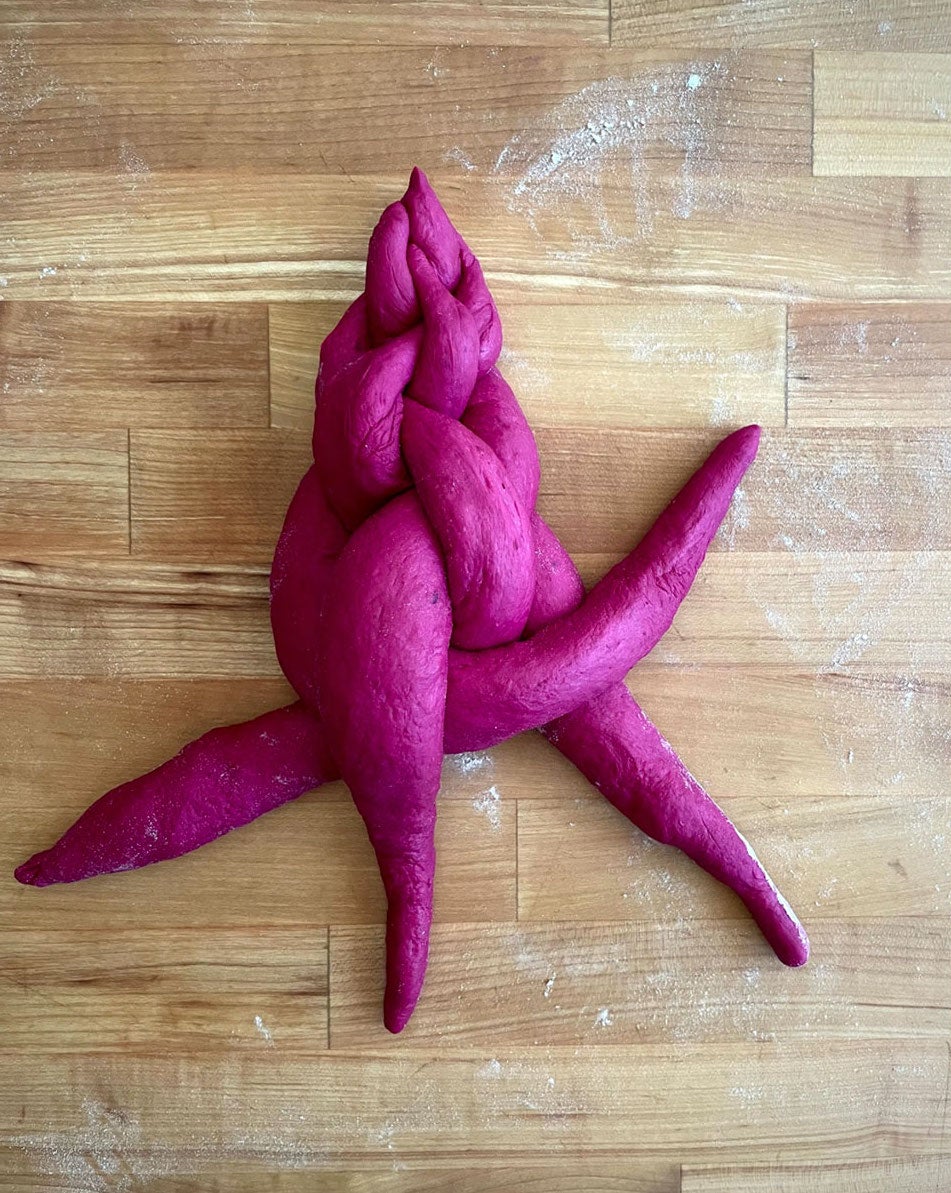 Braided challah next to four-strand braid in progress