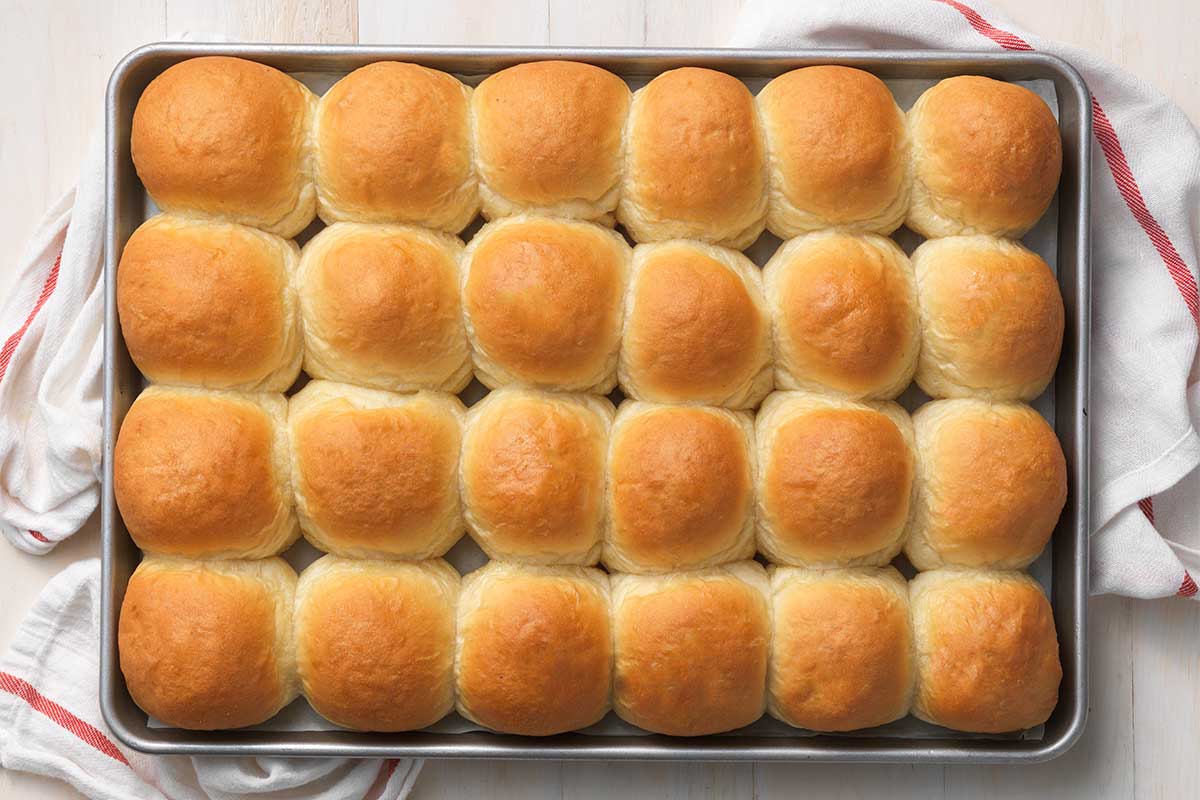 A half-sheet pan filled with golden dinner rolls