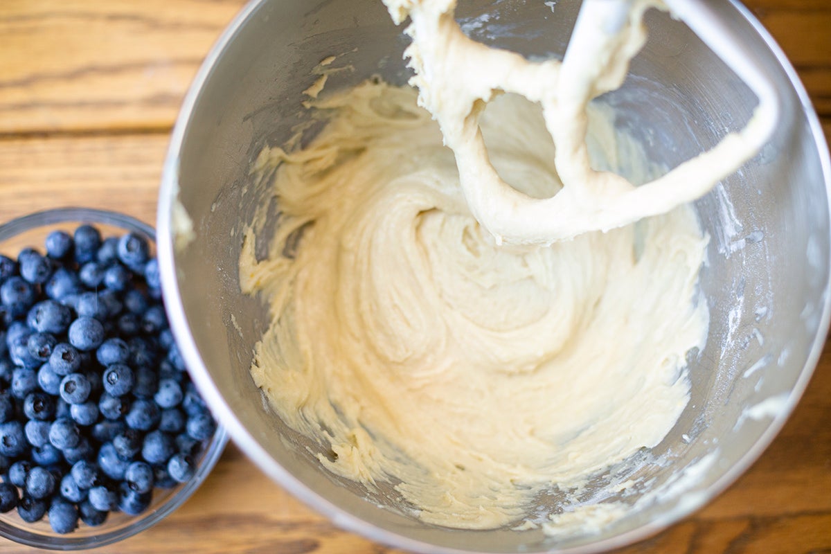 A bowl of Blueberry Buckle Coffeecake batter with fresh blueberries in a bowl