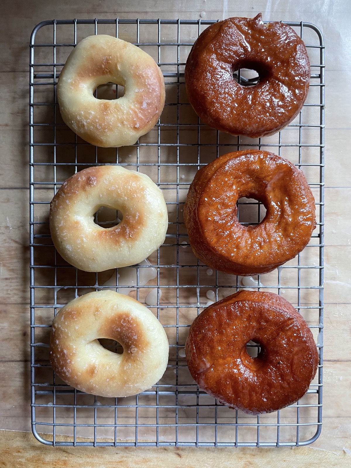 Two rows of yeast-raised doughnuts on a cooling rack: air-fried on the left, fried in hot oil on the right.