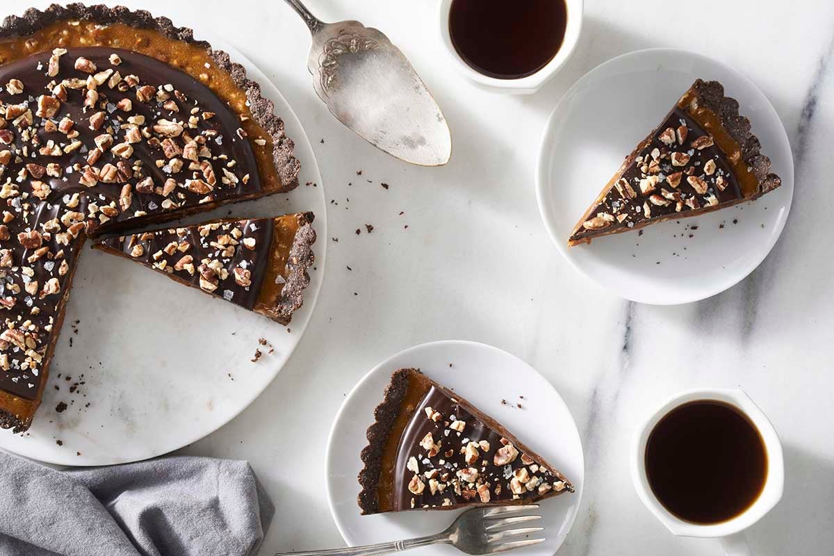 Chocolate caramel tart, with slices cut and plated 