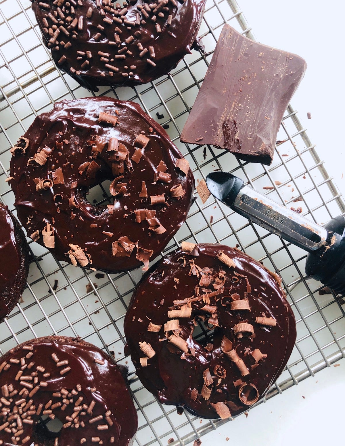 Iced Chocolate Fudge Cake Doughnuts garnished with shaved chocolate.