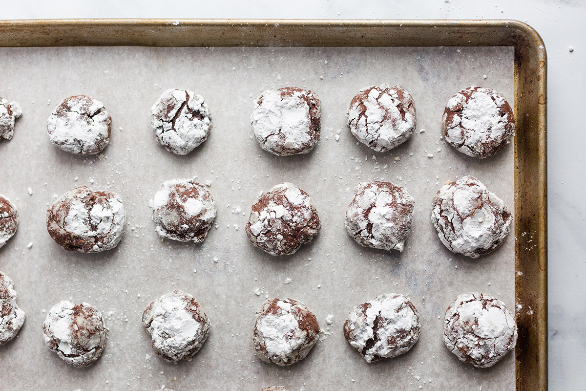 A baking sheet full of freshly baked Chocolate Crinkles fresh from the oven