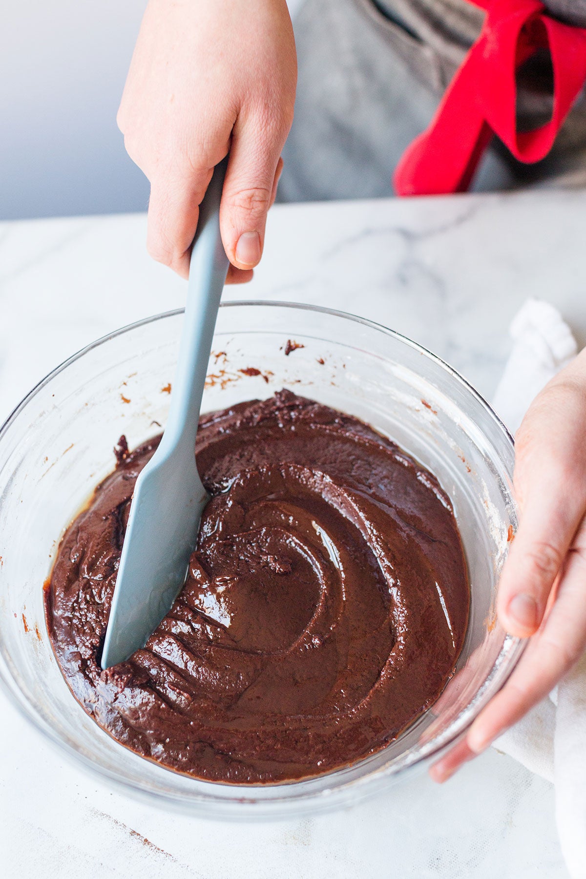 A baker mixing together Chocolate Crinkle dough showing it looks like thick cake batter