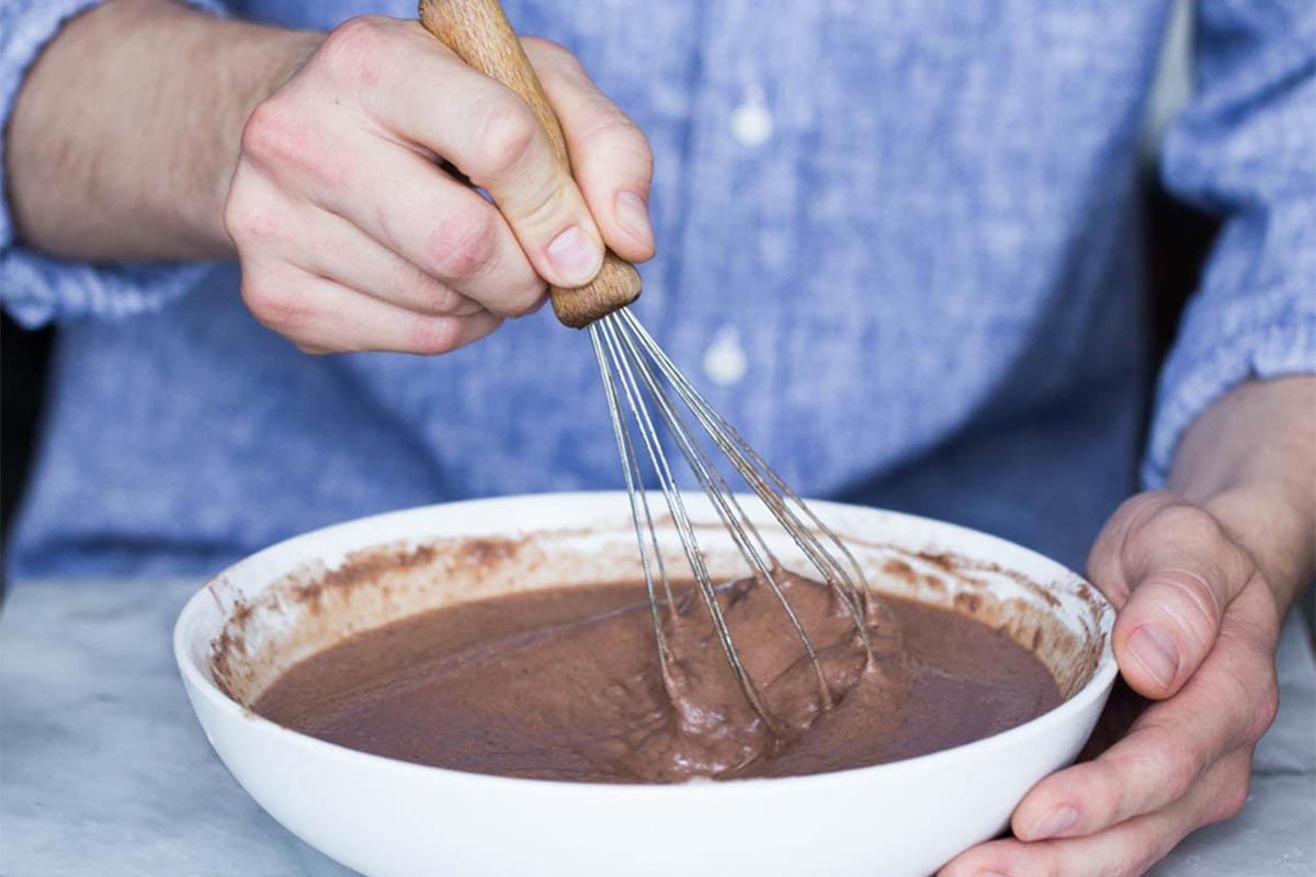 A baker mixing chocolate cake batter
