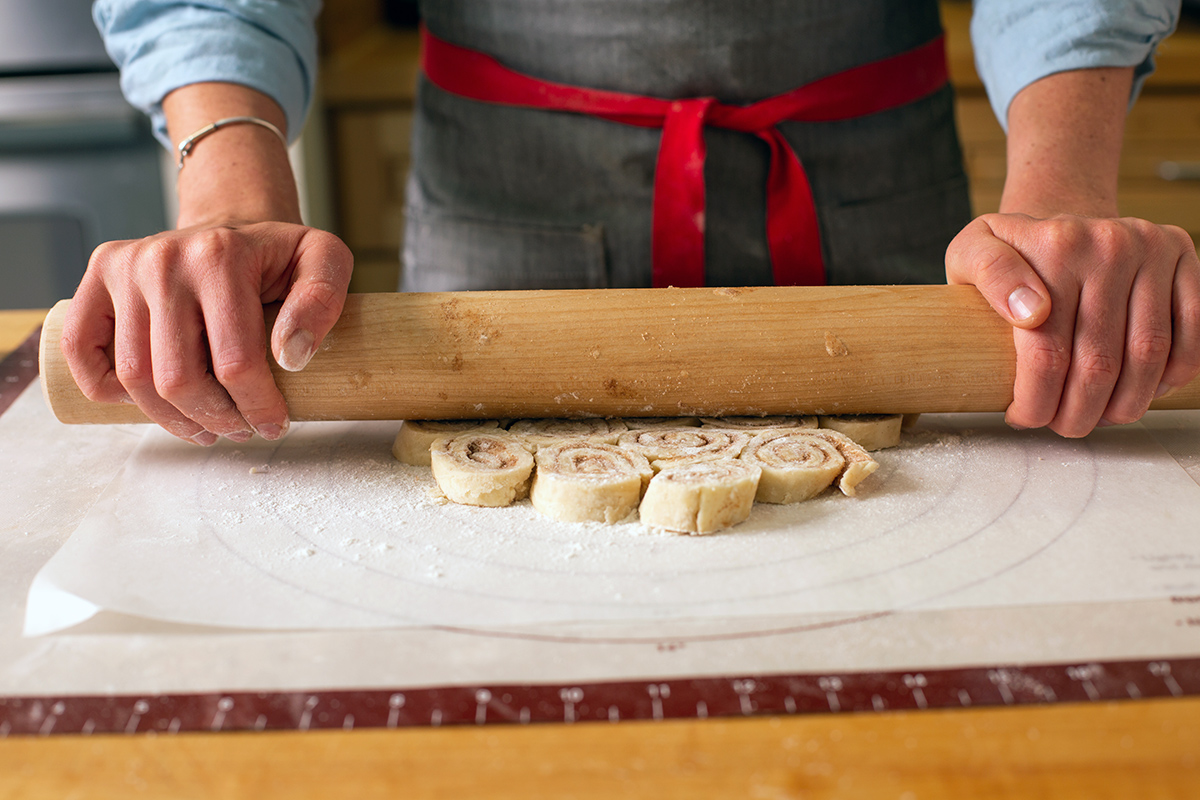 A baker rolling out cinnamon bun pie crust
