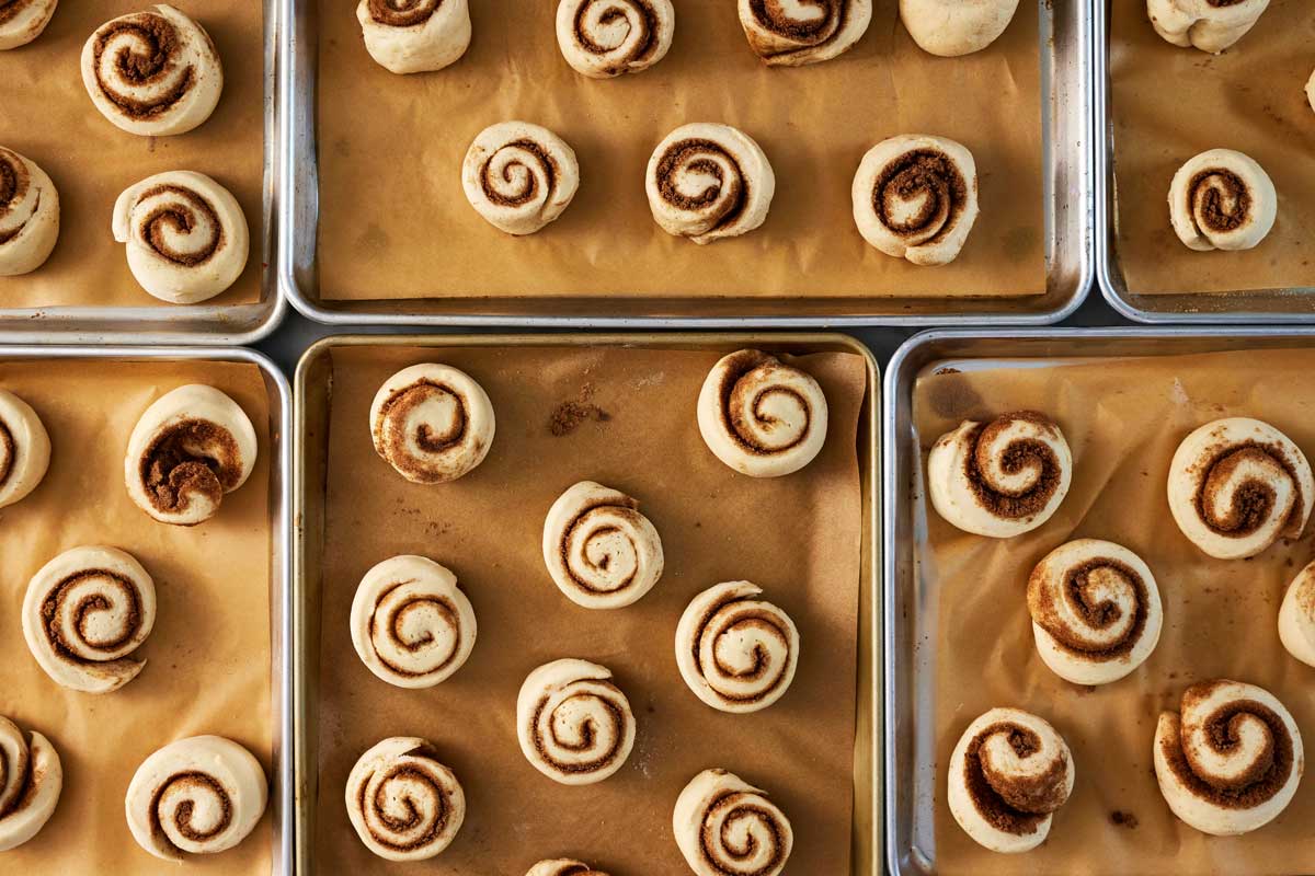 Multiple baking sheets of proofing cinnamon rolls