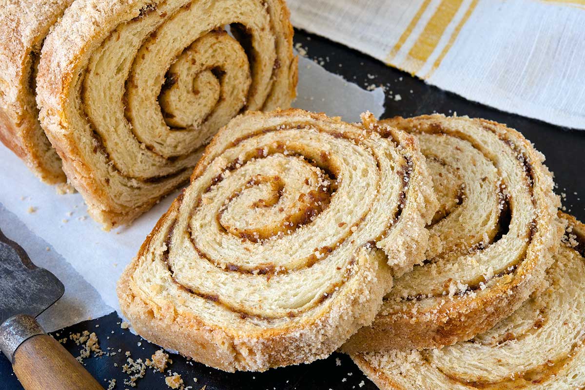 A loaf of streusel-topped cinnamon swirl bread cut into slices