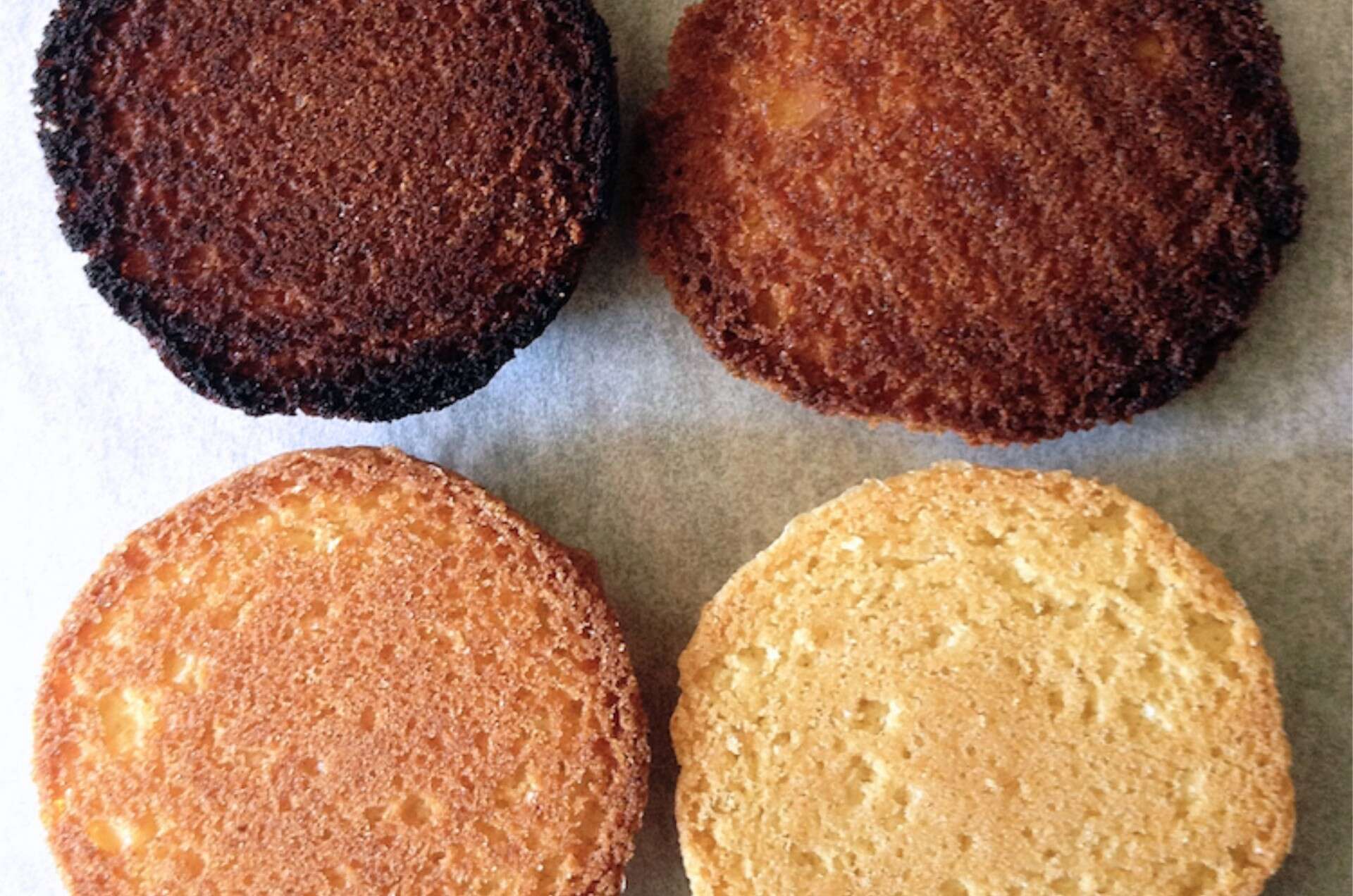 Four cookies bottoms ranging from too brown to very light