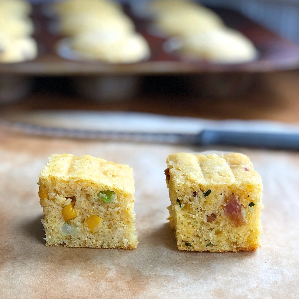 Squares of two kinds of cornbread: fresh corn-scallion, and bacon-cheddar-chive
