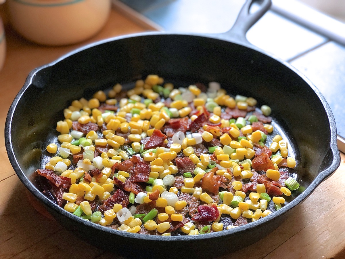 Corn kernels, diced cooked bacon and sliced scallions in a 9" cast iron skillet