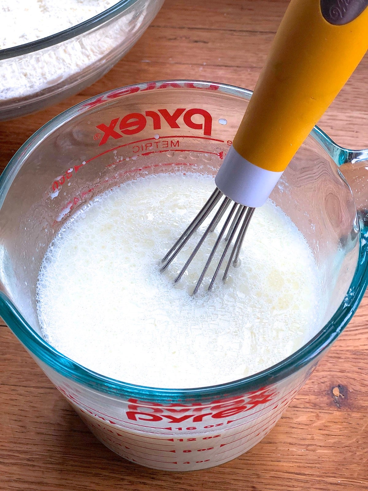 Liquid ingredients for cornbread whisked together in a measuring cup